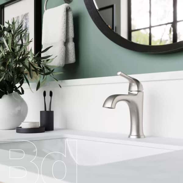 Modern bathroom sink area featuring a brushed metal faucet, white countertop, green wall, round mirror, plant, and towels.