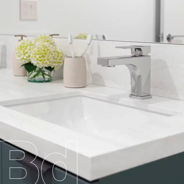 Modern chrome faucet over a white porcelain sink with two light-pink ribbed vases and a bouquet of white flowers on the counter, in a bright bathroom.